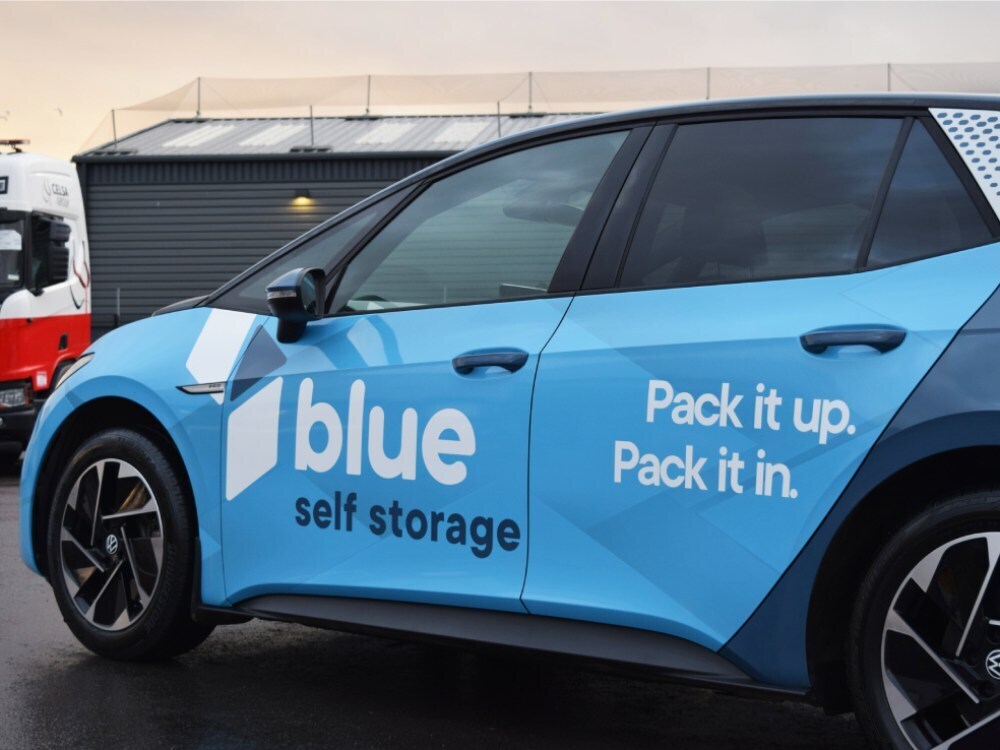 Volkswagen ID3 company car with blue vehicle wrap and branded business graphics.