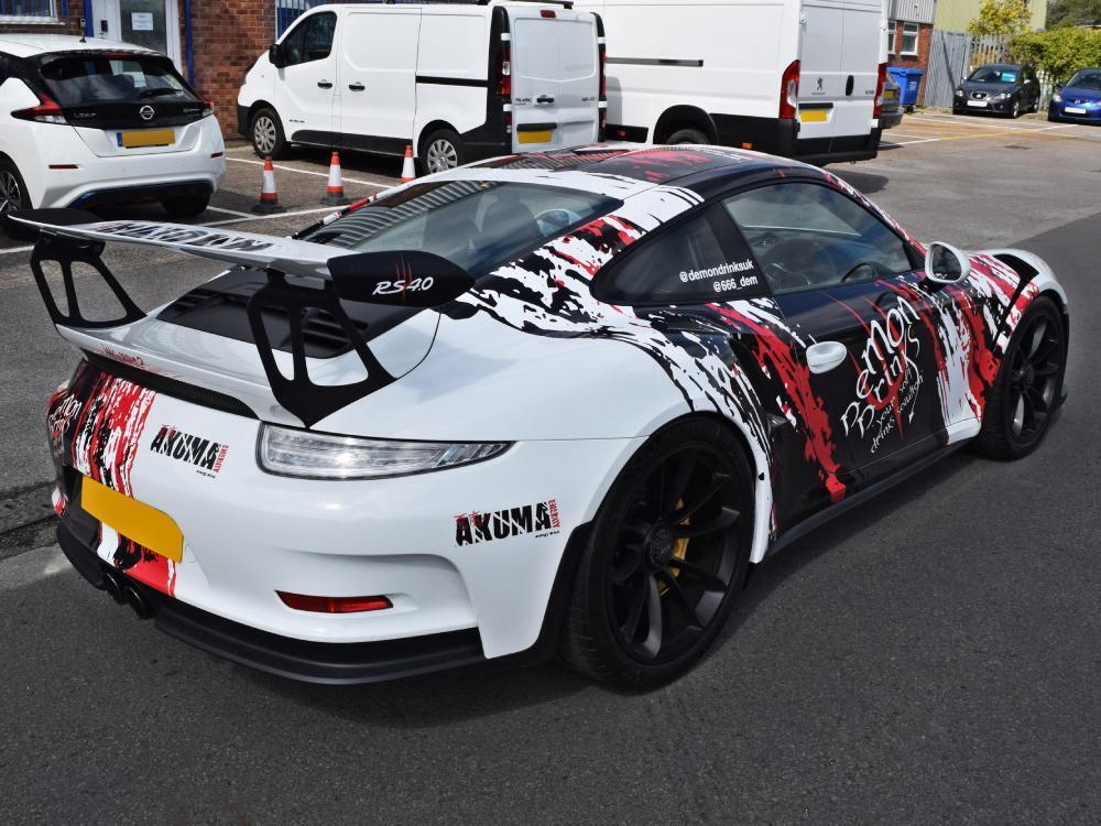 Cool partial vehicle wrap on white company Porsche GT3 RS.