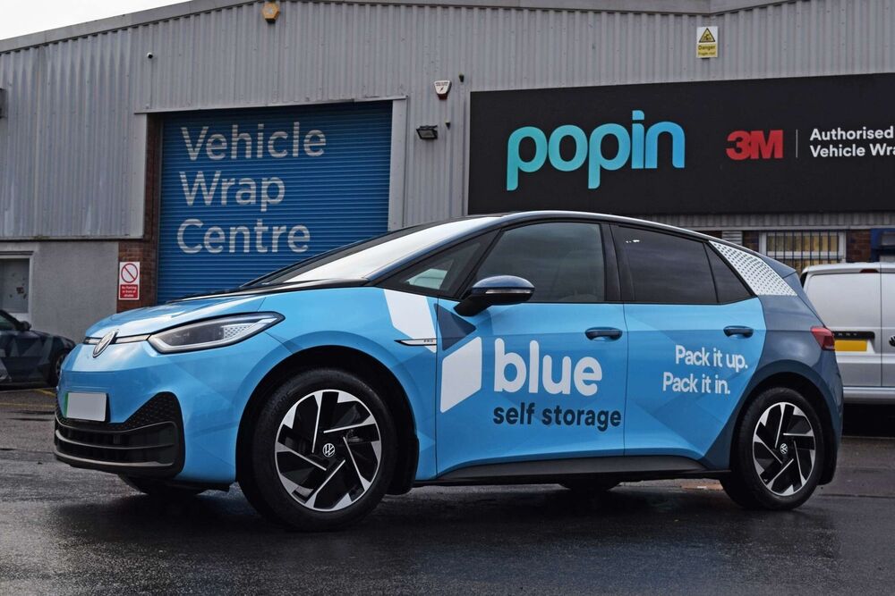 Volkswagen ID3 company car with branded blue vehicle wrap and graphics outside Popin in Cardiff.