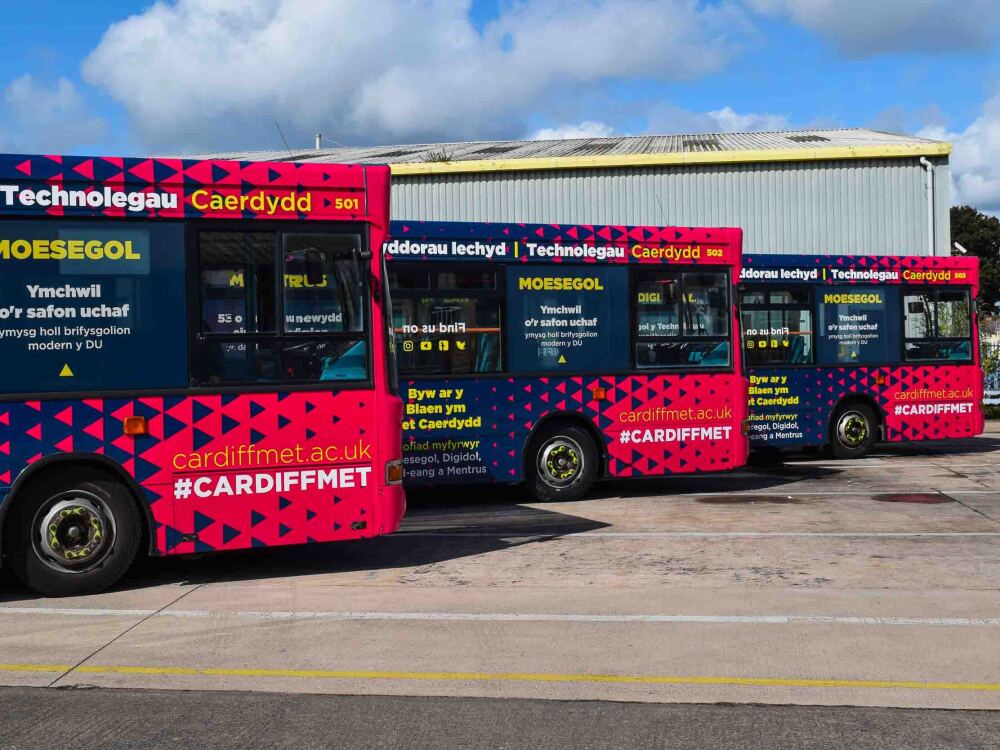 Fleet of Dennis Dart buses with matching Cardiff Metropolitan wraps and vinyl graphics.