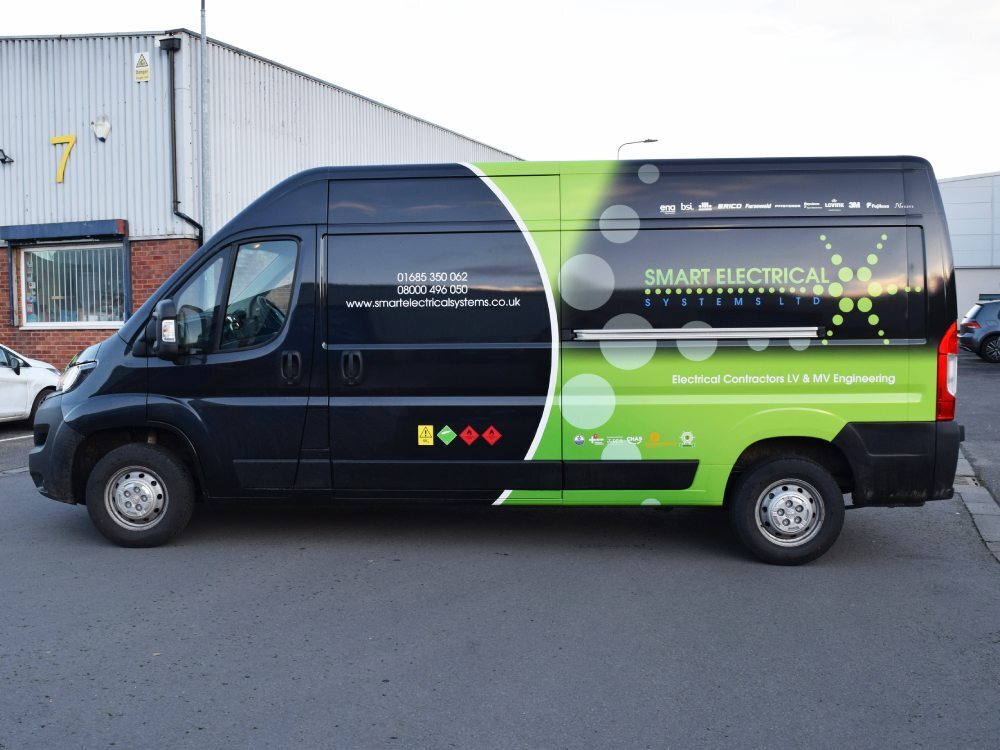 Black Peugeot Boxer van with bright green company branded partial wrap and vinyl graphics.