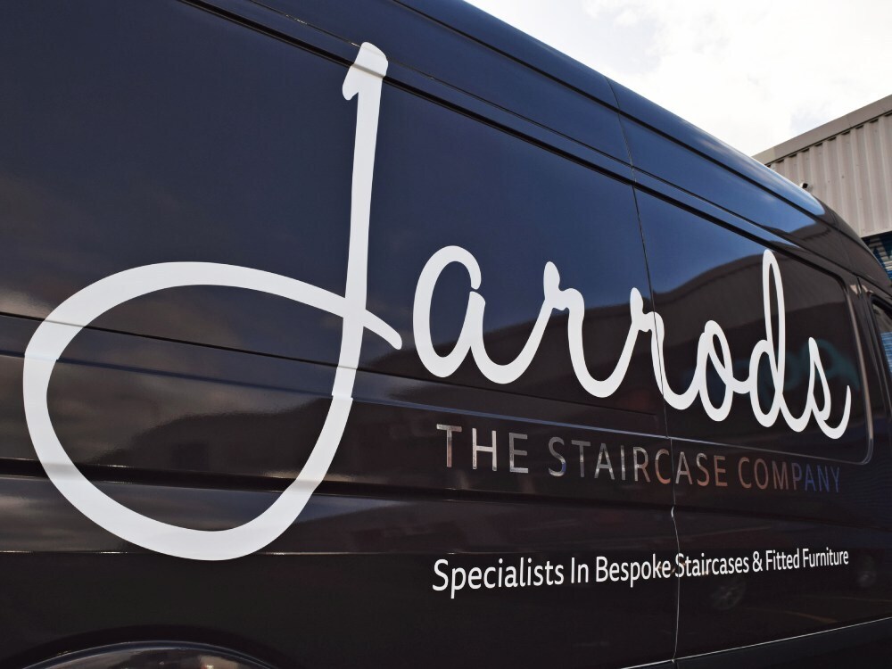 White company branded van vinyl graphics on black Mercedes Sprinter.