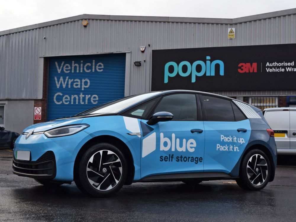 Volkswagen ID.3 electric company car with Blue Self Storage branded vehicle wrap and graphics outside Popin in Cardiff.