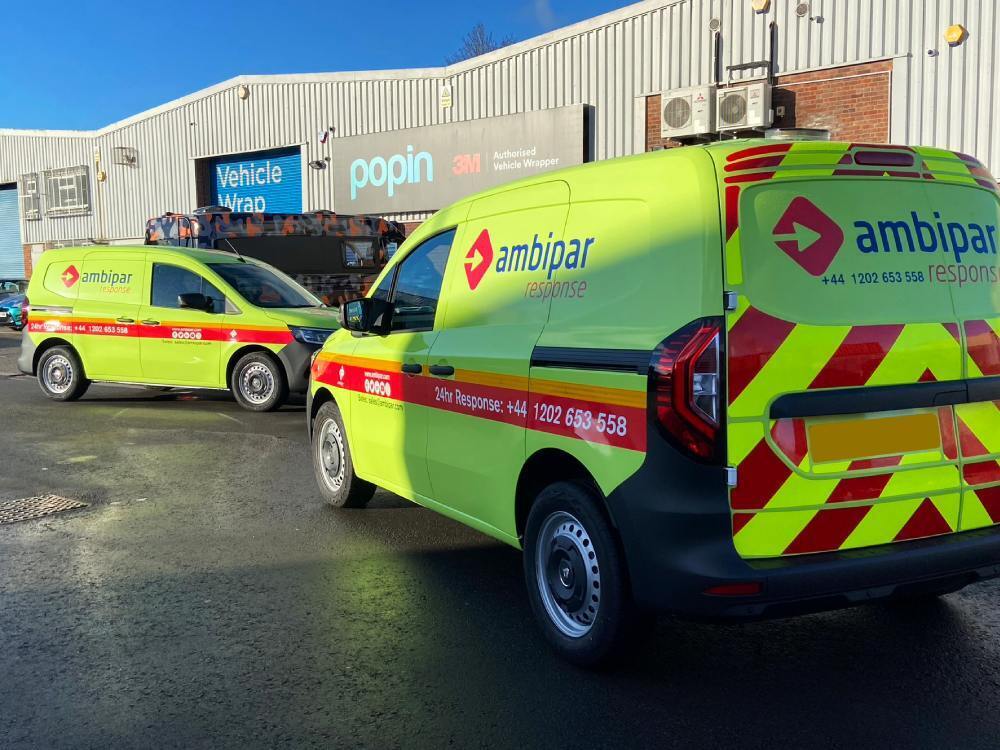 Bright yellow van wraps and chevron graphics on two Renault Kangoo company vehicles.