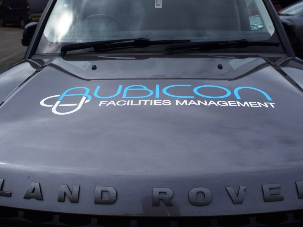 Company branded vinyl graphics on bonnet of Land Rover Discovery.