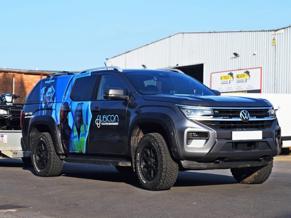Rear partial branded vehicle wrap on Volkswagen Amarok company car.