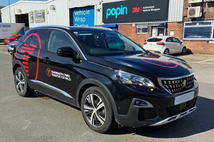 Black Peugeot 3008 company vehicle car with branded vinyl graphics outside Popin in Cardiff.
