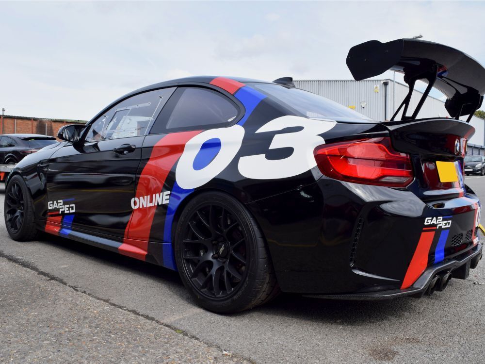 Motorsport graphics and decals on a BMW M2 race car