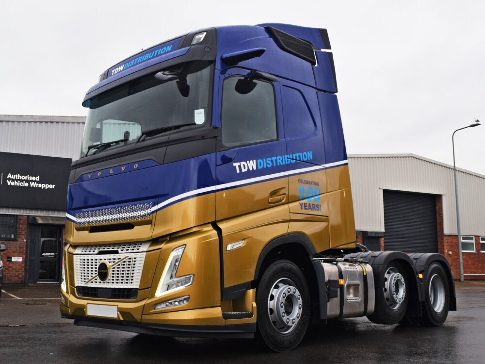 Blue and gold vehicle livery on a Volvo lorry cab.