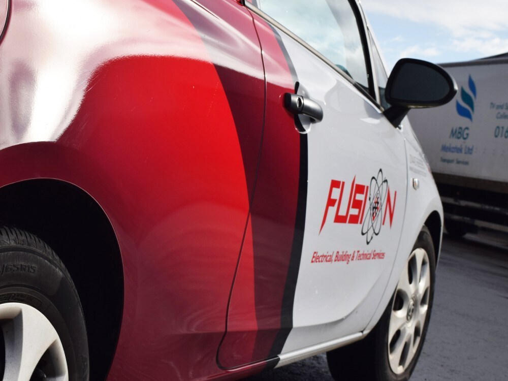 Branded partial vehicle wrap and graphics on Vauxhall Corsa company car.