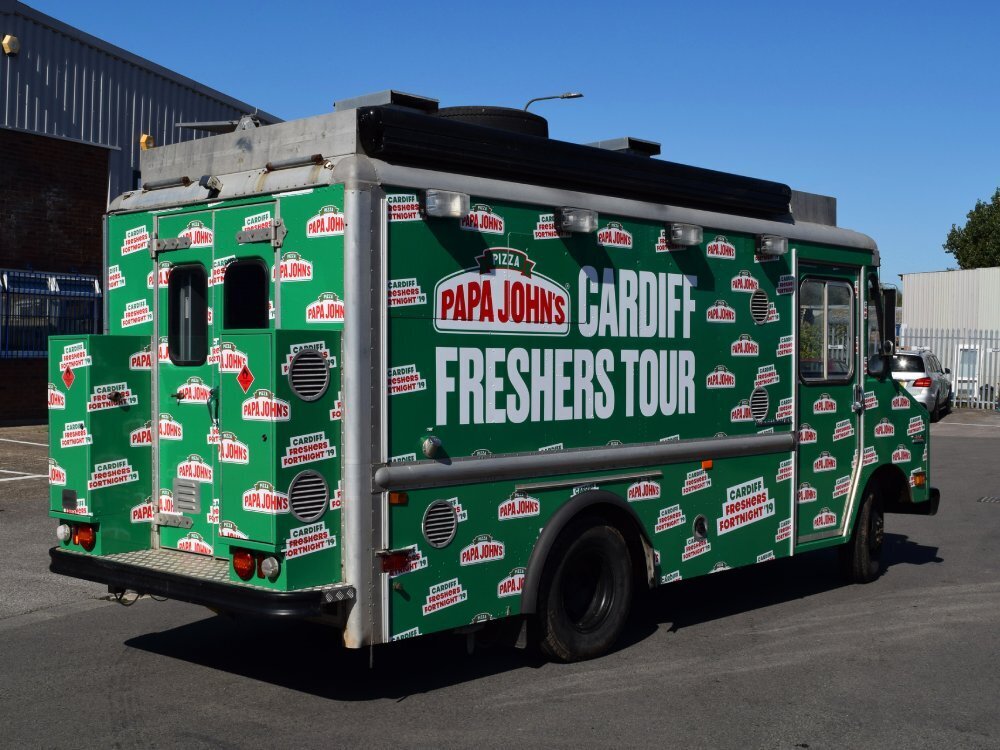 Green Papa Johns pizza vehicle wrap on a GMC truck.