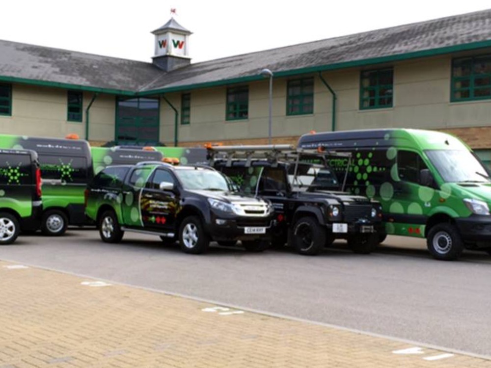 Fleet of company vans and other vehicles with matching branded vinyl wraps and graphics.