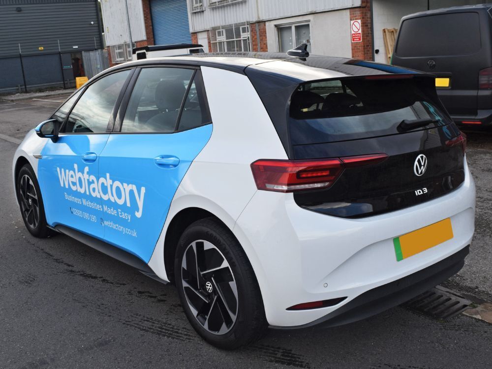 Rear end of Volkswagen ID3 company car with branded partial vehicle wrap and graphics.