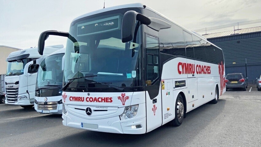 White Mercedes Tourismo coach with red Cymru Coaches company branded vinyl graphics.