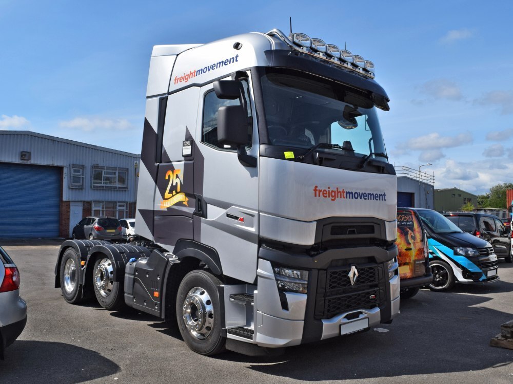 Vehicle wrap and graphics on a silver Renault truck parked in a depot.