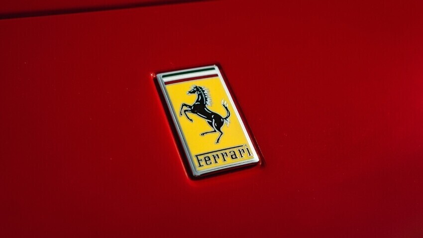 Ferrari badge on red car.