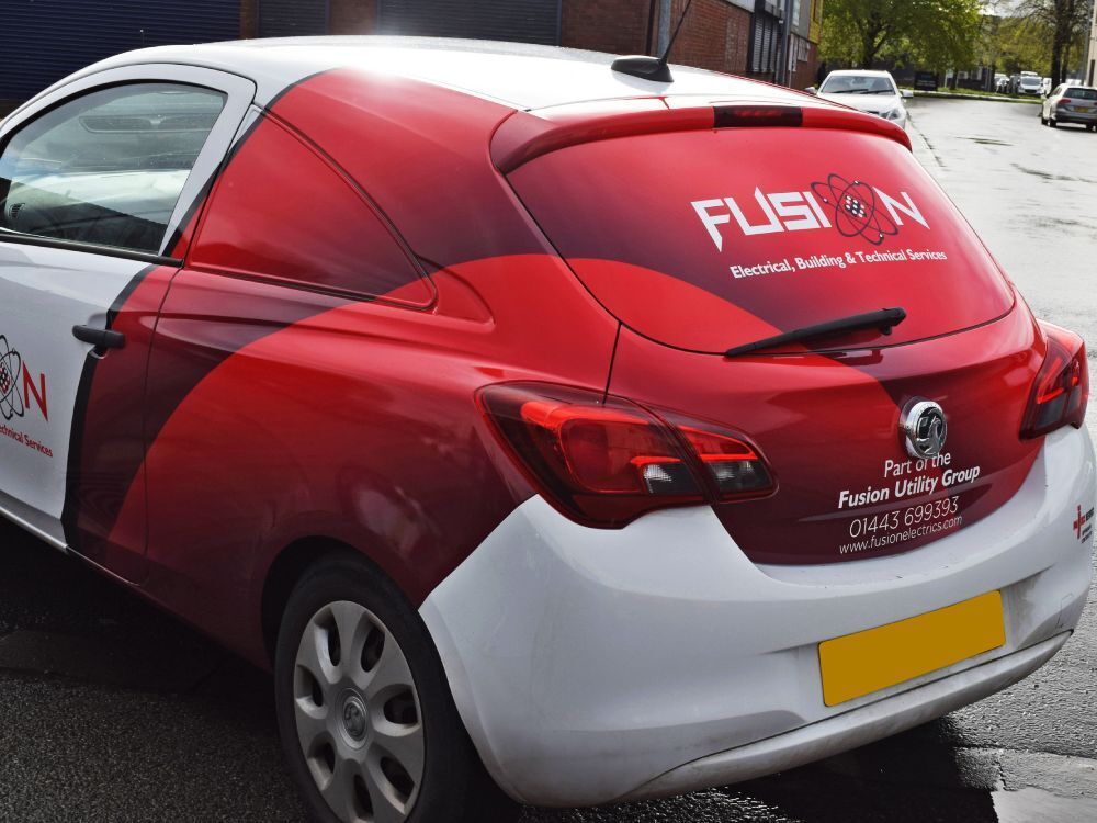 Red partial vehicle wrap and branded vinyl graphics on rear of white Vauxhall Corsa company car.