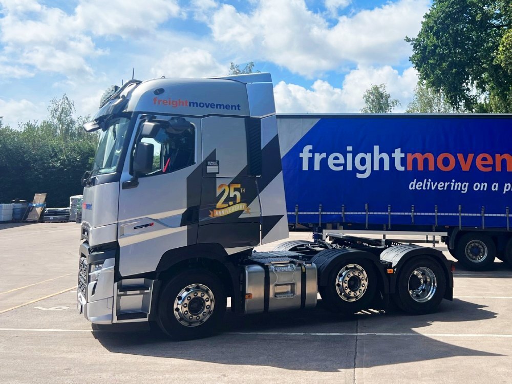 Vehicle livery and vinyl graphics on a Renault truck parked in a depot.