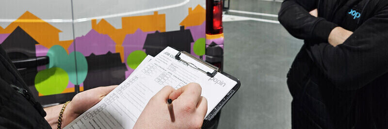 Vehicle graphics on a van being quality inspected by wrap installation technicians at Popin in Cardiff.