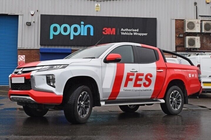 White and red vinyl graphics and partial wrap on company Mitsubishi L200 outside Popin in Cardiff.