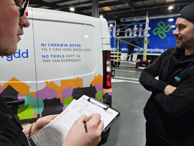 Vehicle wrappers at Popin Graphics going through a pre-wrap checklist