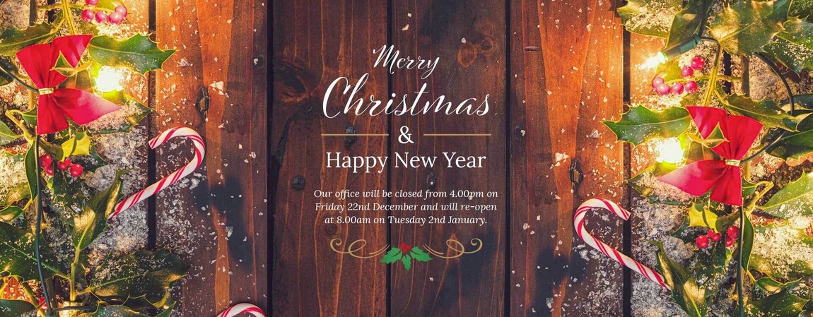 An example banner image of a cosy Christmas scene showing a wooden door framed with Christmas decorations, with a Merry Christmas message in the middle wishing visitors a Merry Christmas and a Happy New Year.