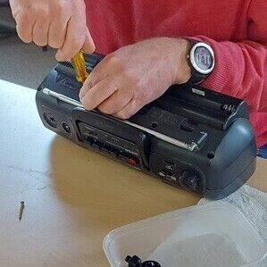 Repair Hub volunteer working on a CD player