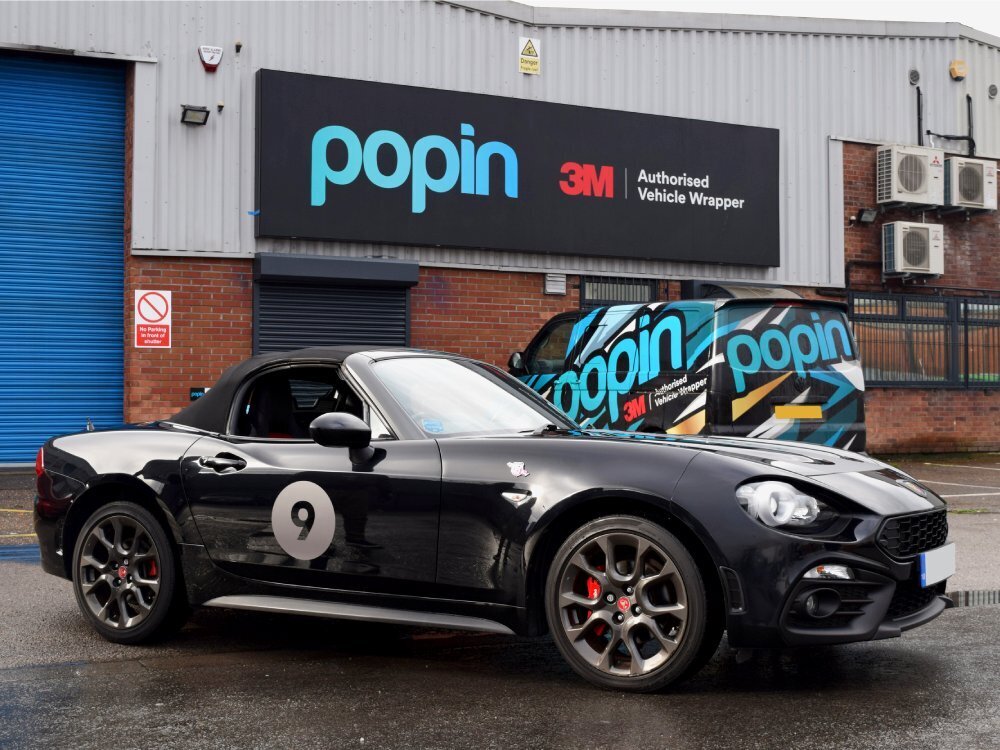 Black Abarth 124 Spider with number 9 race decal outside Popin Graphics in Cardiff