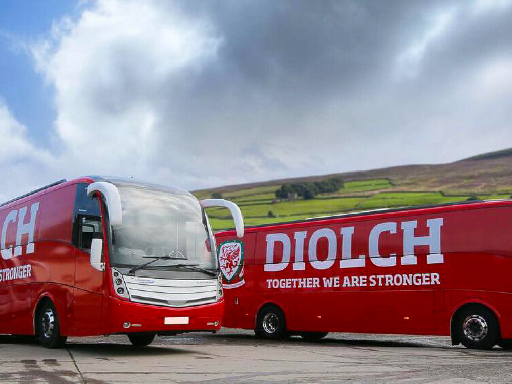 Fleet of Caetani Levante coaches with red FA Wales branded livery and graphics.