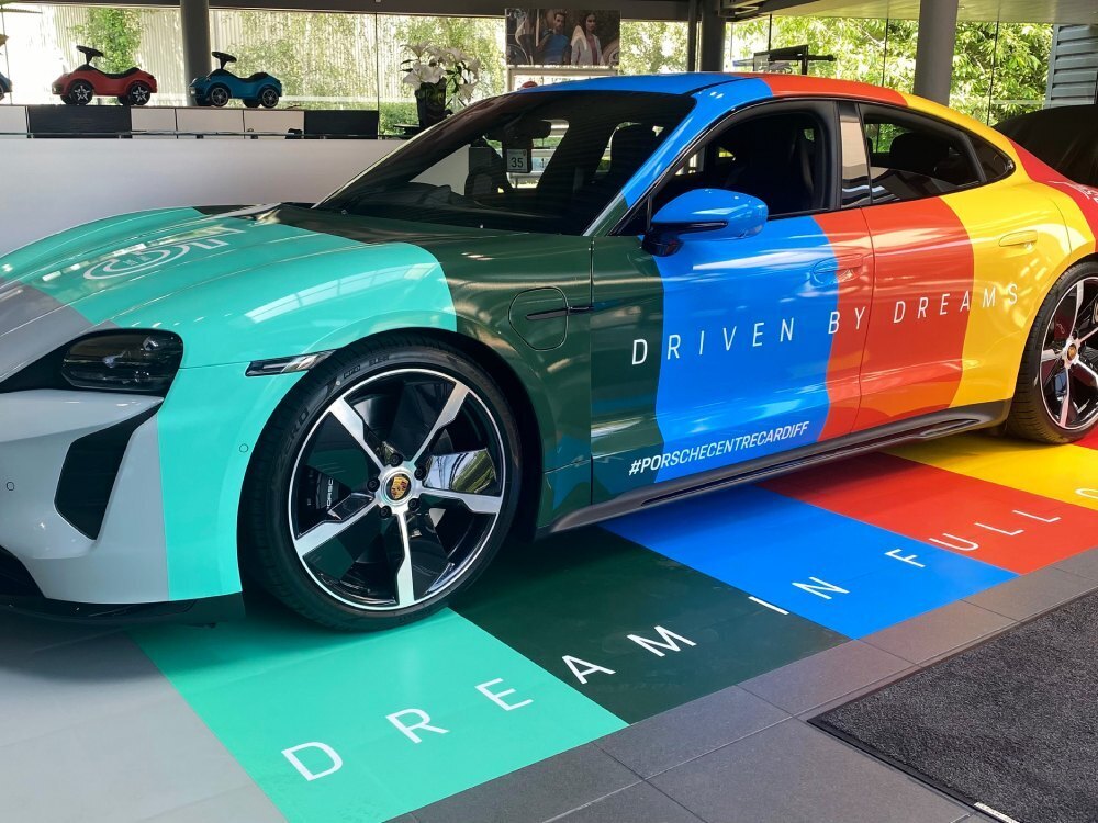 Colourful motorsport wrap on a Porsche Taycan Turbo in Cardiff showroom