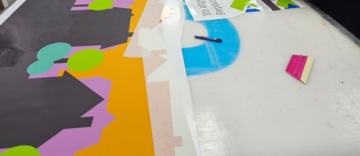 Application tape holding cut vehicle vinyl graphics in place.