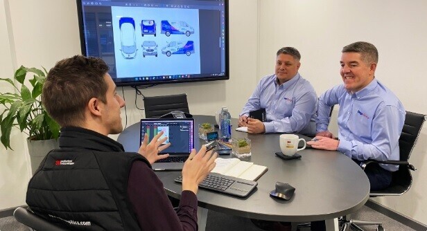 Customers in Popin headquarters discussing vehicle vinyl graphics design.