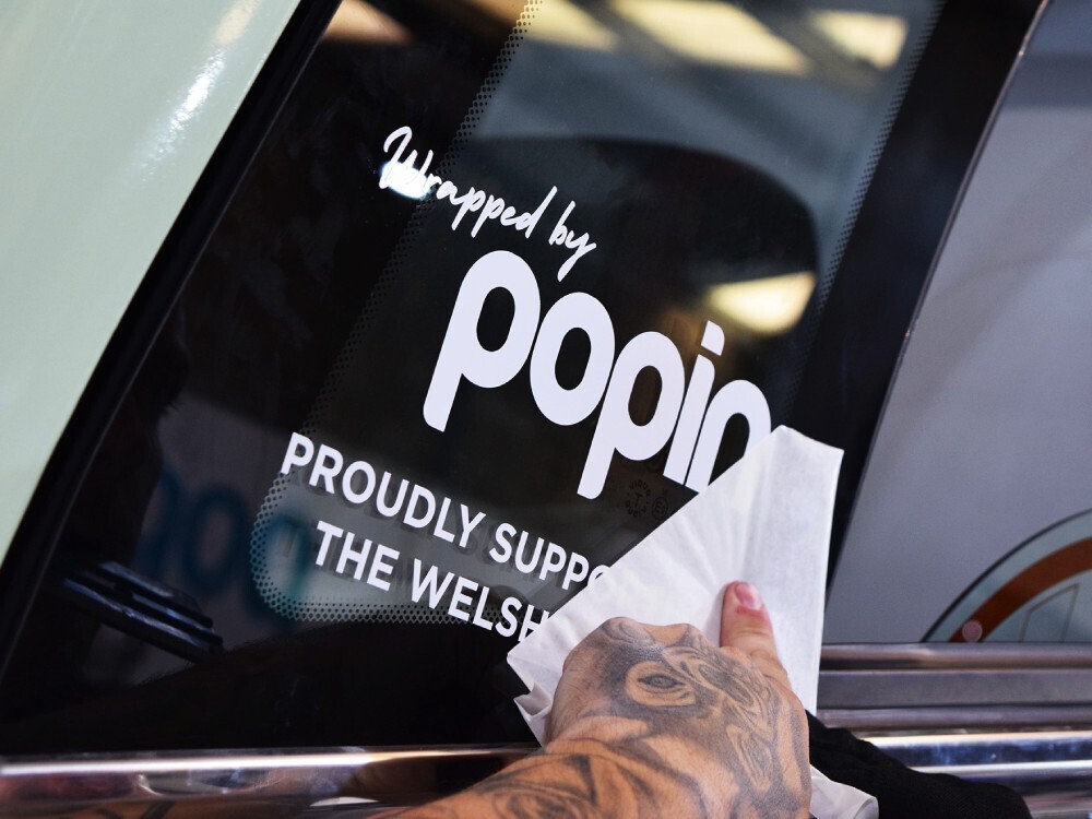 Window graphics being installed on Scania Irizar coach.