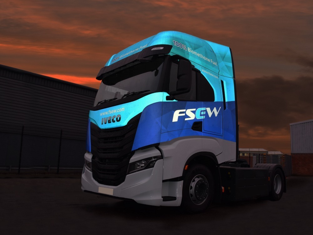 Reflective vehicle graphics on an IVECO lorry at night.