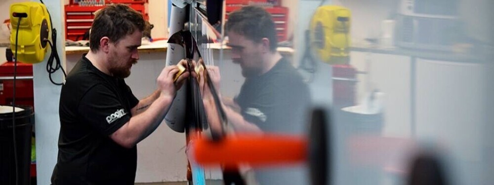 Promotional vinyl graphics being applied to a vehicle by a technician at Popin in Cardiff.