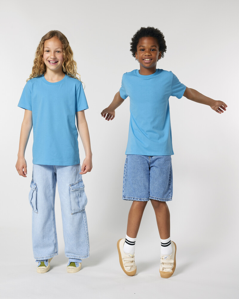 Kids in unisex Mini Creator 2.0 Stanley/Stella aqua blue t-shirts with cargo pants and shorts, ideal for eco-friendly kidswear printing.