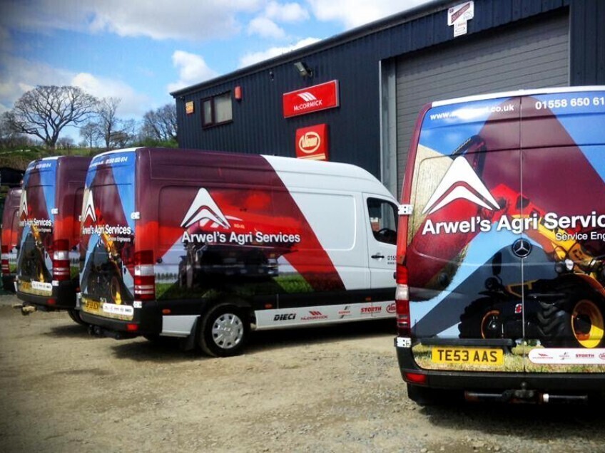 Fleet of company vans with matching vehicle vinyl wraps and graphics.