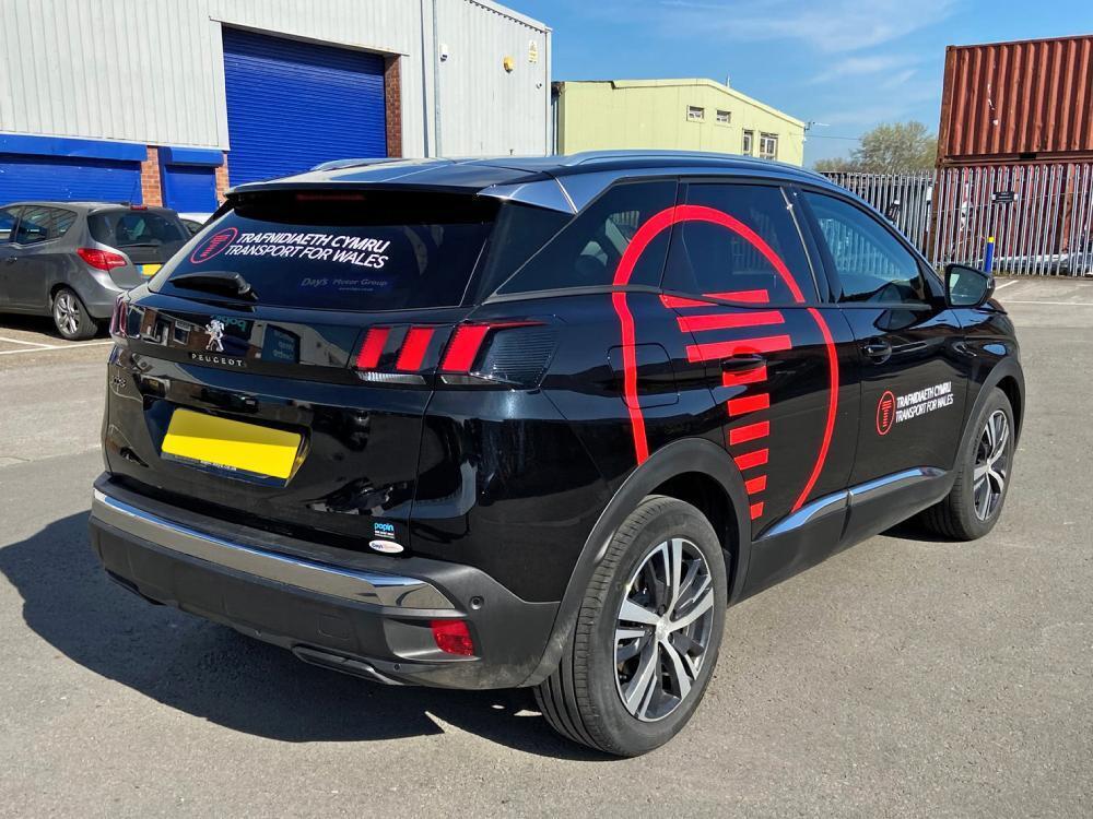 Branded vinyl graphics on black Peugeot 3008 company car.