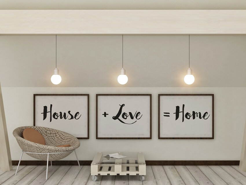 An image of 3 frames with the words “House +Love =Home” written on them next to a chair, which are examples of the finishing touches that Catherine Brennan, Interior Designer of New Forest Designs, offers when providing Home Interior Design Services.