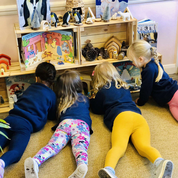 Preschool children playing in the book snug