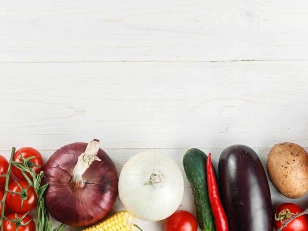 A row of vegetables placed on a wooden board.