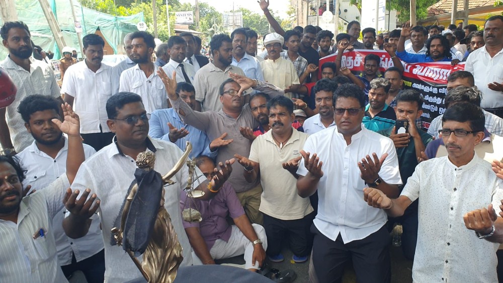 நீதி தேவதைக்கு முன்பாக மண்டியிட்ட போராட்டக்காரர்கள்