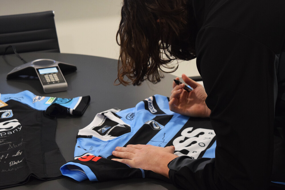 Rory Thornton of Cardiff Rugby signing a shirt for his sponsors Popin Graphics
