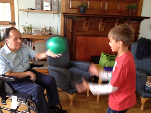 Image of Natasha's son playing catch with a stroke client on 'take your kid to work day' at Eryl Fryn Care Home in Llandudno 2016