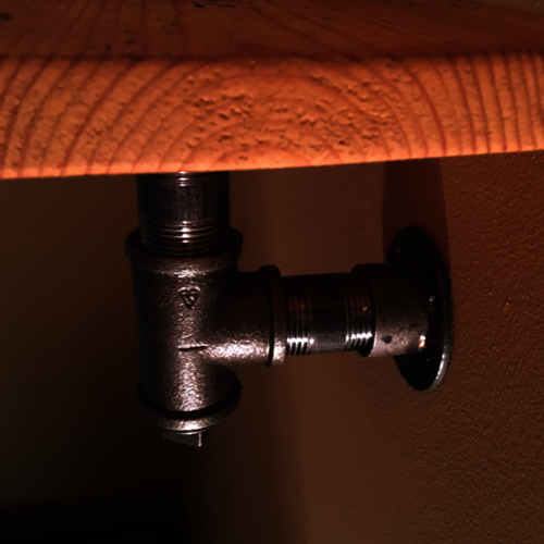 Reclaimed rustic wood shelf with industrial pipe brackets