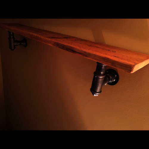Reclaimed rustic wood shelf with industrial pipe brackets
