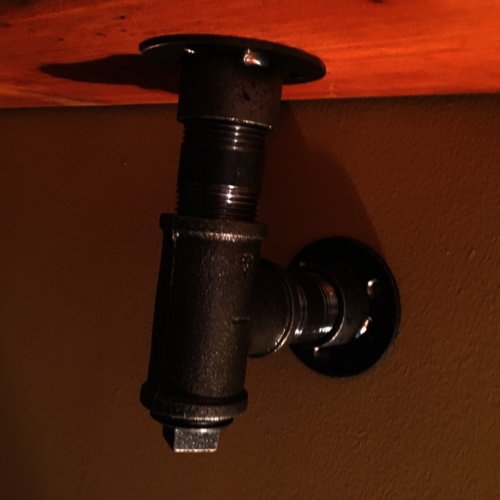 Reclaimed rustic wood shelf with industrial pipe brackets